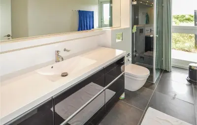 a bathroom with a sink and a toilet at Stunning Home In Løkken With Kitchen in Løkken