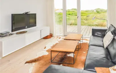 a living room with a couch and a tv at Stunning Home In Løkken With Kitchen in Løkken