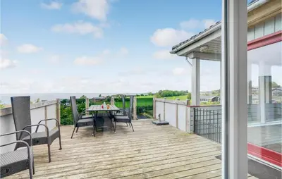 a patio with a table and chairs on a deck at Three-Bedroom Holiday Home In Farso in Farsø