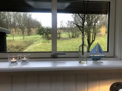 a window with candles and a sail boat on a counter at Heltoften Bed & Breakfast in Nykøbing Mors