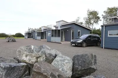 a car parked in front of a row of houses at Tangsø Hytteby in Bækmarksbro