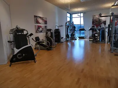 a gym with several treadmills and exercise bikes at Tangsø Hytteby in Bækmarksbro