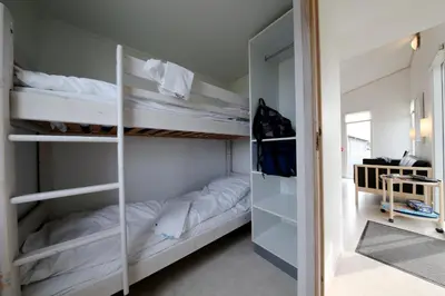 a room with two bunk beds and a hallway at Tangsø Hytteby in Bækmarksbro