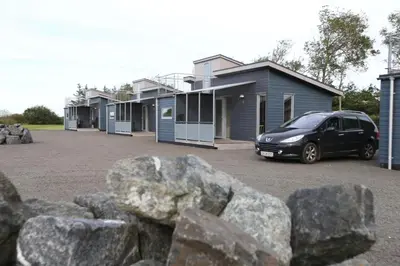 a car parked in front of a row of houses at Tangsø Hytteby in Bækmarksbro