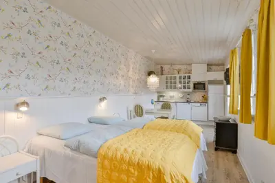 a bedroom with a large bed and a kitchen at Viborg City Rooms in Viborg