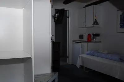 a small room with a bed and a kitchen at Viborg City Rooms in Viborg