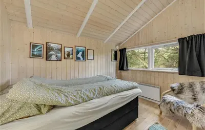 a bedroom with a bed in a room with wooden walls at Three-Bedroom Holiday Home In Hurup Thy in Sindrup