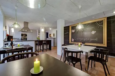 a restaurant with tables and chairs and a chalkboard at B & B Langagergaard in Thisted