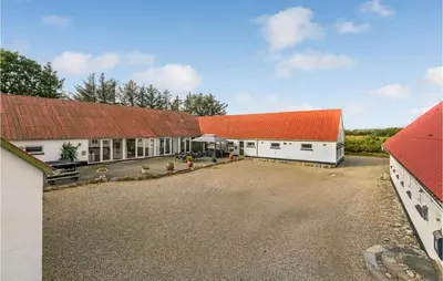 a large white building with an orange roof at Bakkegården in Thisted