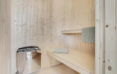 a sauna with a wooden wall with a sink at Seven-Bedroom Holiday Home In Spottrup in Spottrup
