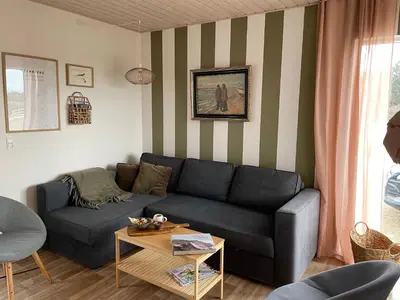 a living room with a couch and a table at Stenbjerg Kro & Badehotel in Snedsted