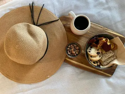 a hat and a plate of food and a cup of coffee at Stenbjerg Kro & Badehotel in Snedsted
