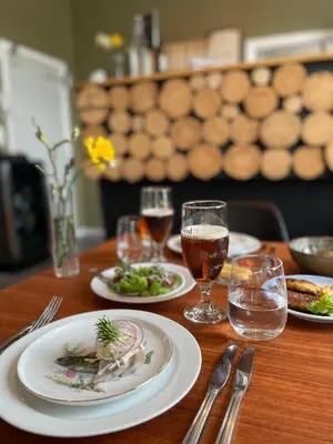a wooden table with plates of food and glasses of wine at Stenbjerg Kro & Badehotel in Snedsted