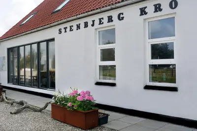 a white building with the sign for a store at Stenbjerg Kro & Badehotel in Snedsted