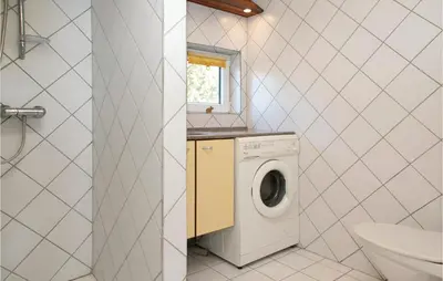a bathroom with a washing machine and a sink at Three-Bedroom Holiday Home In Blokhus in Blokhus