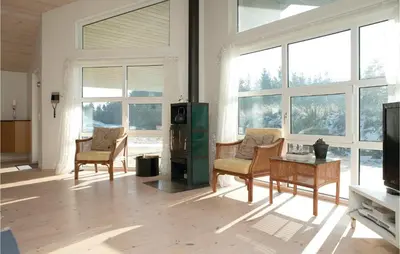 a living room with furniture and large windows at Three-Bedroom Holiday Home In Blokhus in Blokhus