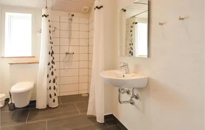 a bathroom with a sink and a toilet and a mirror at Four-Bedroom Holiday Home In Vestervig in Vestervig