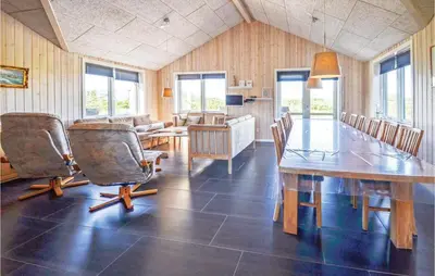 a dining room with a wooden table and chairs at Four-Bedroom Holiday Home In Vestervig in Vestervig