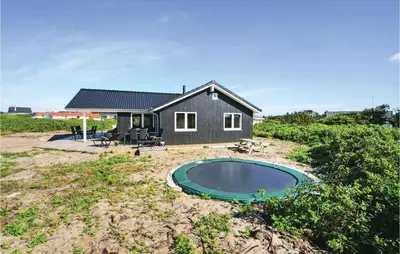 a small black house with a pool in front of it at Four-Bedroom Holiday Home In Vestervig in Vestervig