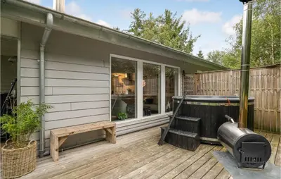 a screened in porch with a hot tub on a deck at Four-Bedroom Holiday Home In Spottrup in Spottrup
