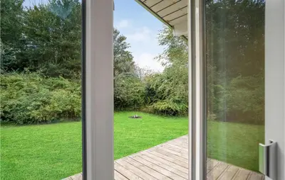 a sliding glass door looking out at a yard at Four-Bedroom Holiday Home In Spottrup in Spottrup