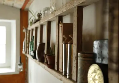a shelf filled with pots and a clock on a wall at Porshus Ferielejlighed in Sundstrup