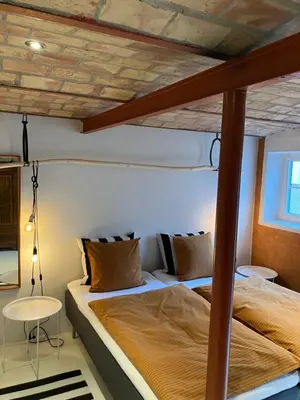 a bedroom with two beds and a wooden ceiling at Porshus Ferielejlighed in Sundstrup