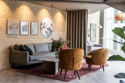 a living room with a couch and two chairs and a table at Comwell Rebild Bakker in Skorping