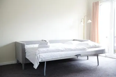 a bed with white sheets and pillows in a bedroom at Montra Hotel Hanstholm in Hanstholm