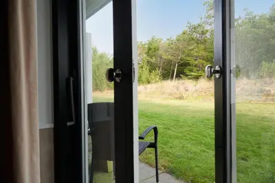 an open door with a chair looking out at a field at Montra Hotel Hanstholm in Hanstholm