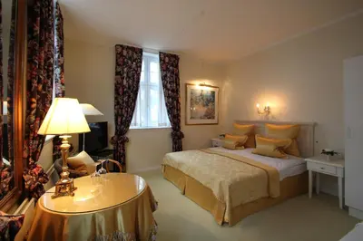 a bedroom with a bed and a table with a lamp at Store Restrup Manor House in Store Restrup