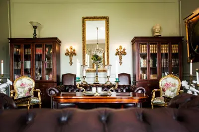 a living room with a table and chairs and a mirror at Store Restrup Manor House in Store Restrup