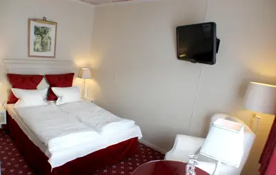 a hotel room with a bed and a television at Store Restrup Manor House in Store Restrup
