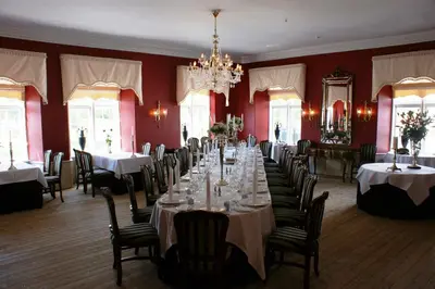 a dining room with tables and chairs and a chandelier at Store Restrup Manor House in Store Restrup
