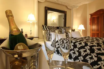a hotel room with two champagne glasses and a bed at Kokkedal Slotshotel in Brovst