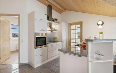a kitchen with white cabinets and a stove top oven at Three-Bedroom Holiday Home In Vinderup in Vinderup