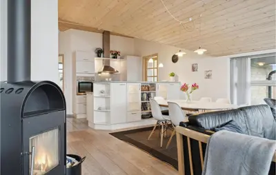 a living room with a fireplace and a dining room at Three-Bedroom Holiday Home In Vinderup in Vinderup