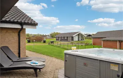 a chair sitting on a patio with a hot tub at Three-Bedroom Holiday Home In Vinderup in Vinderup