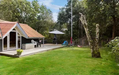 a backyard with a house and a swing at Three-Bedroom Holiday Home In Thyholm in Thyholm
