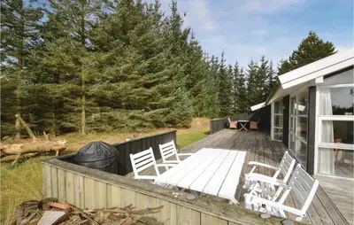 a deck with white chairs on a house at Four-Bedroom Holiday Home In Fjerritslev in Fjerritslev