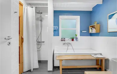 a bathroom with a white tub and a sink at Four-Bedroom Holiday Home In Fjerritslev in Fjerritslev