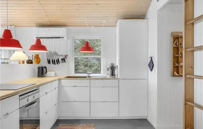 a kitchen with white cabinets and red pendant lights at Four-Bedroom Holiday Home In Fjerritslev in Fjerritslev