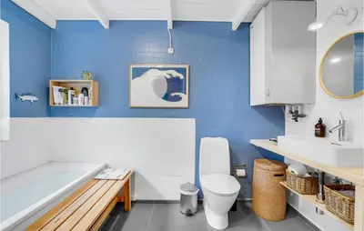 a bathroom with a tub and a toilet and a sink at Four-Bedroom Holiday Home In Fjerritslev in Fjerritslev