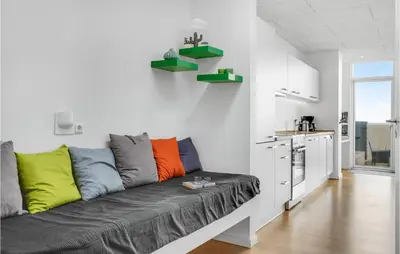 a living room with a couch with colorful pillows at One-Bedroom Holiday Home In Ulfborg in Ulfborg