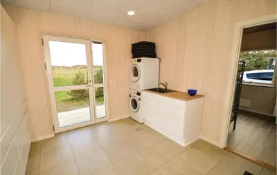 a kitchen with a washing machine and a window at Three-Bedroom Holiday Home In Skals in Skals