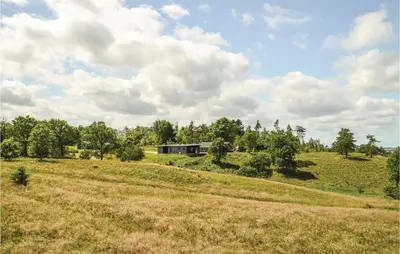 a field with a house in the middle of it at Three-Bedroom Holiday Home In Skals in Skals