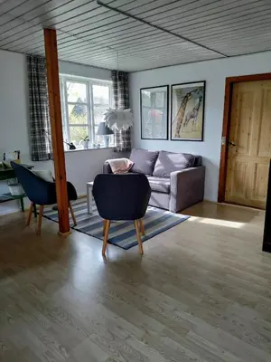 a living room with a couch and a table at Slettegaard in Slettestrand