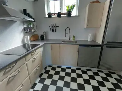 a kitchen with a black and white checkered floor at Thy Ferielejlighed in Thisted