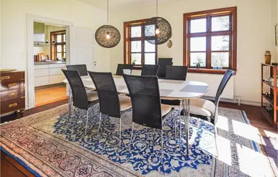a dining room with a white table and black chairs at Venøhus in Struer