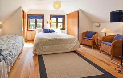 a bedroom with a bed and two chairs at Venøhus in Struer